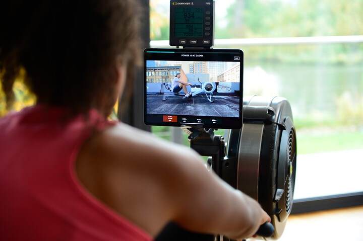 Woman rowing while using an app on a tablet